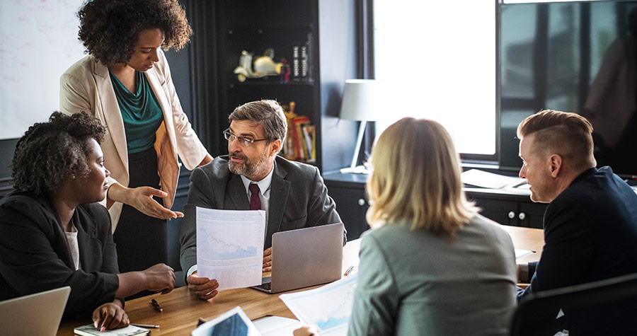 Empresários em reunião discutindo sobre seguro de vida empresarial